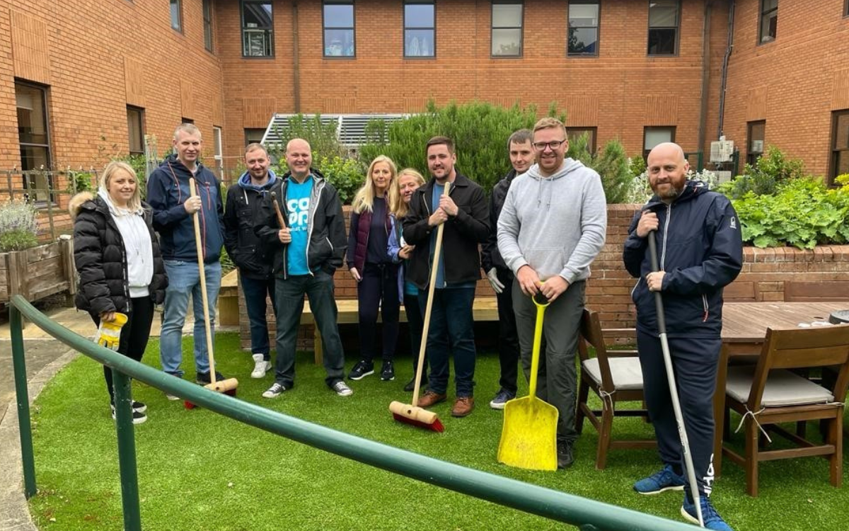 10 corporate volunteers gardening at the forget me not un it at Warrington Hospital.