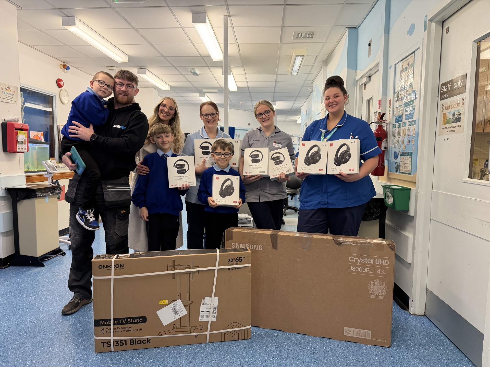Matt Lamb his wife Jemma and sons, Corey (9), Dougie (8) and Stanley (6) with staff on the children’s ward at Warrington Hospital.