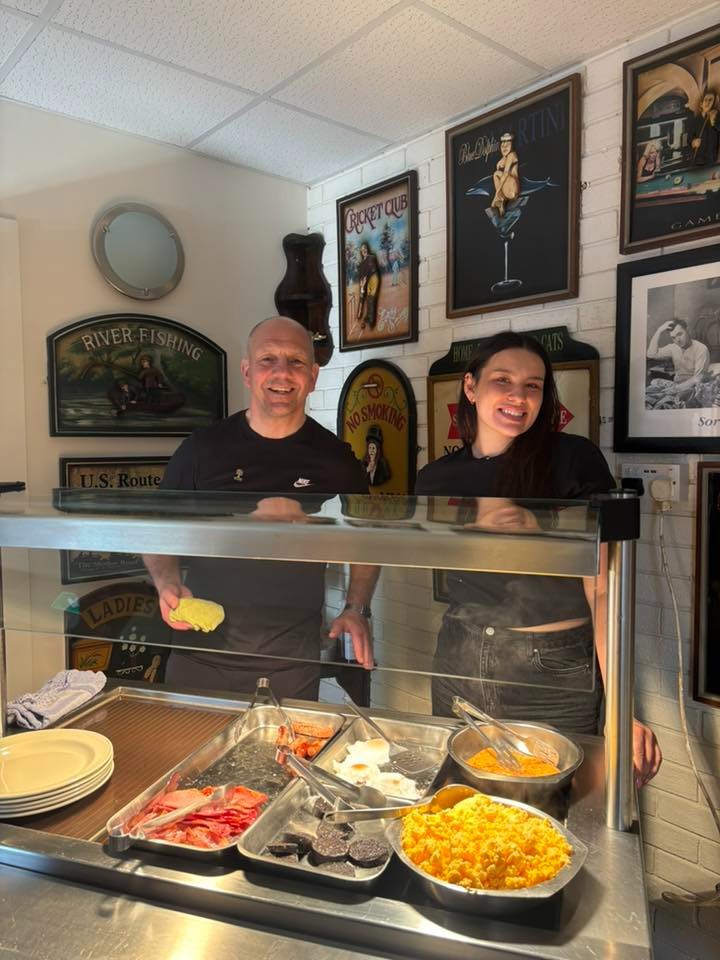 Two members of the Culcheth Village Club team making breakfast.