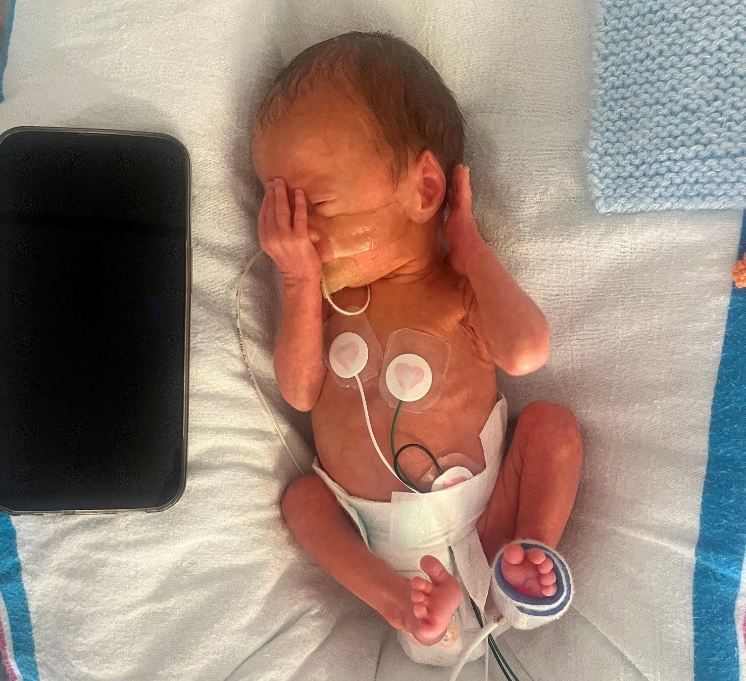 One of three triplets in their bed.