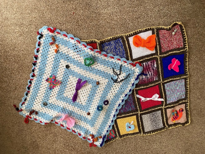Two multicoloured knitted blankets.