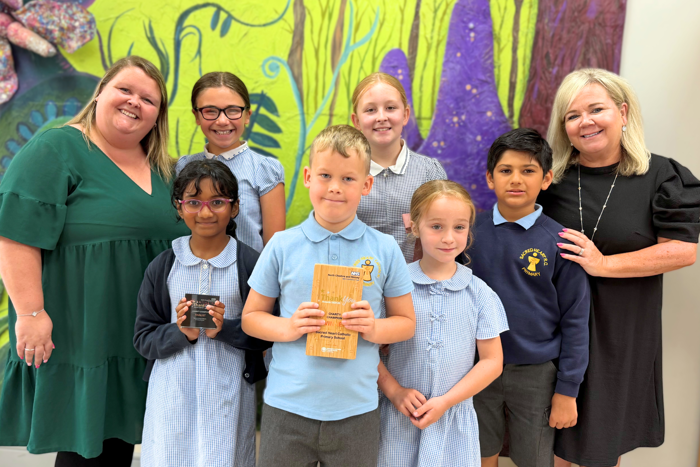 Pupils and staff at Sacred Heart Catholic Primary School smiling with their award.